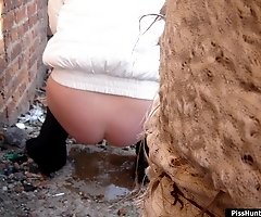 Sexy girl caught taking a leak behind a building
